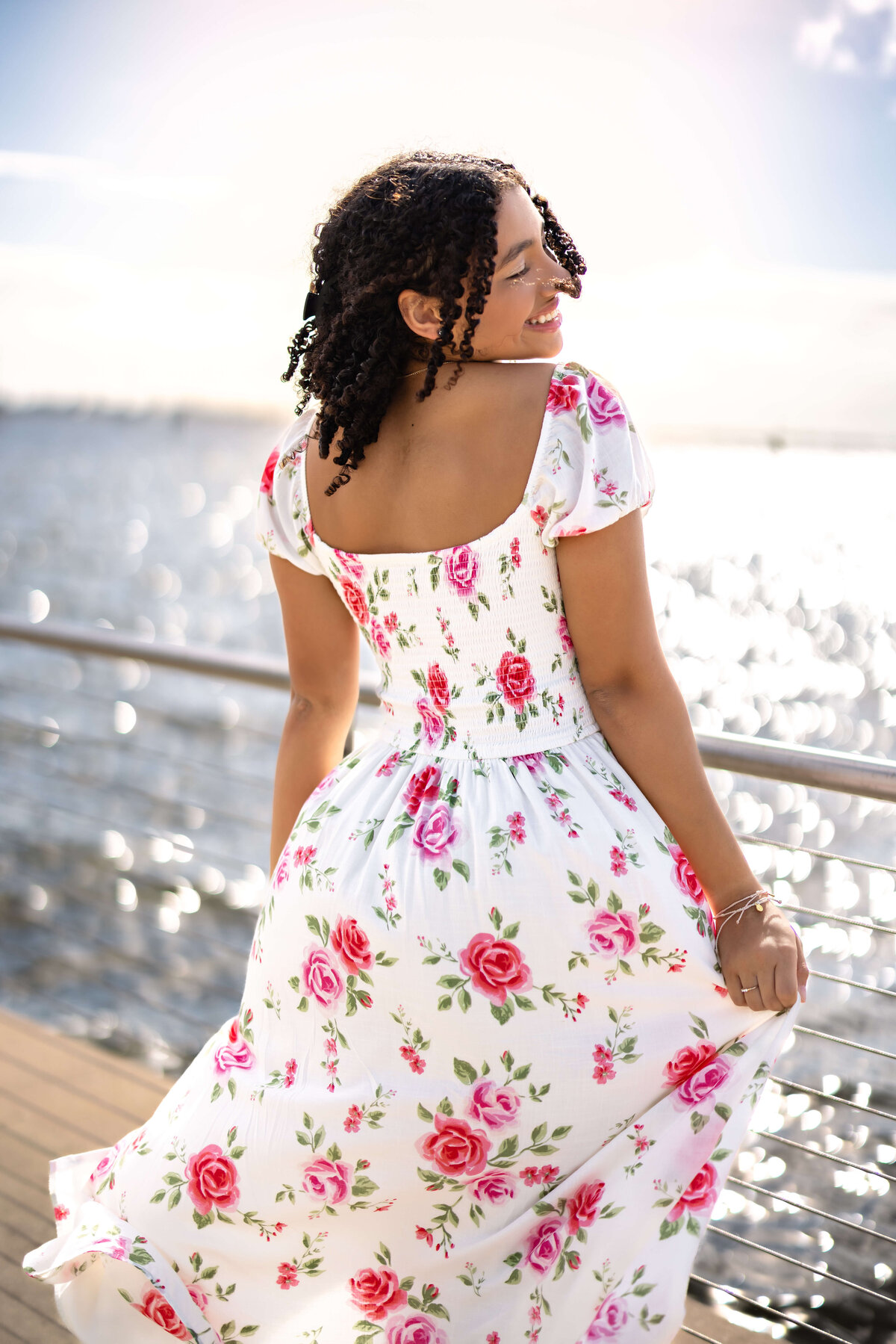 Windermere senior session near the waterfront docks, girl spinning in a white and pink floral dress, editorial beach movement 