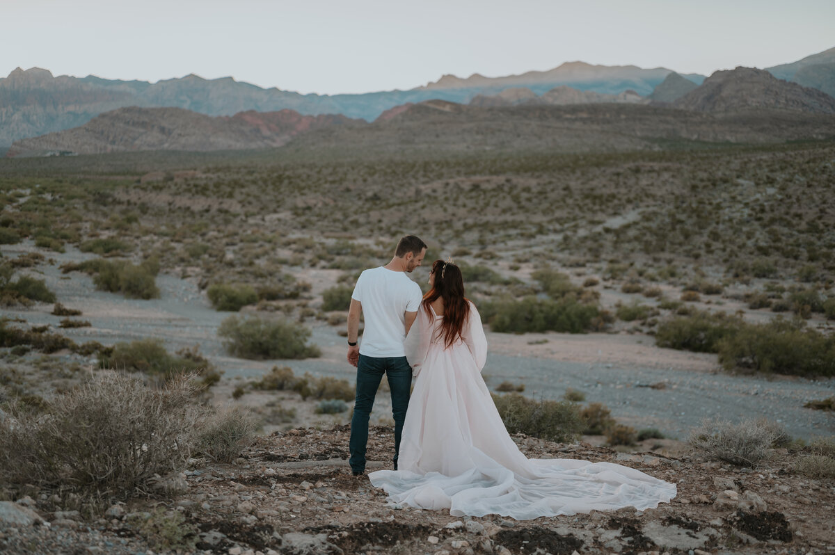 a cute couple in red rock canyon las vegas posing for their wedding photographer