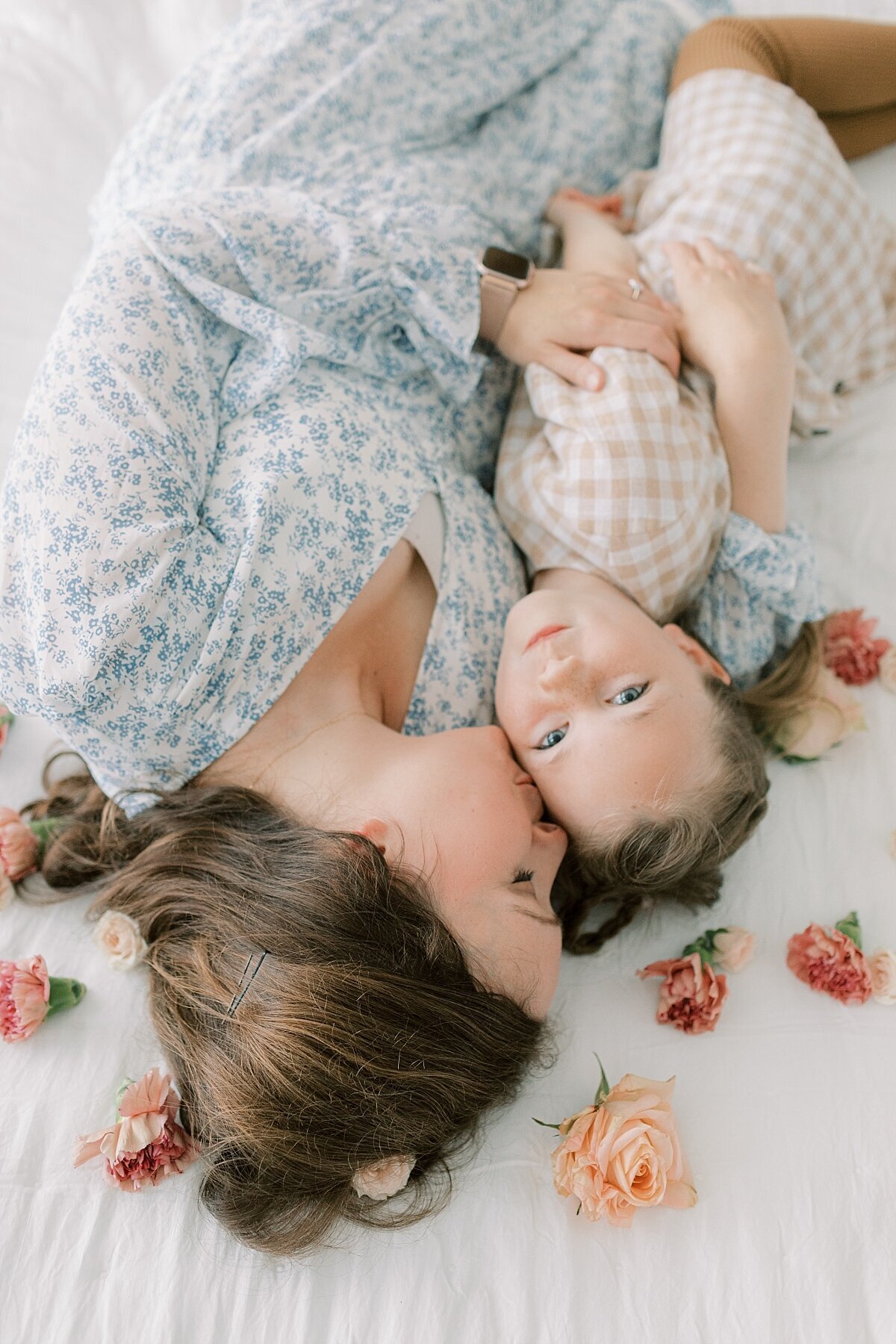 mom and daughter laying among flowers