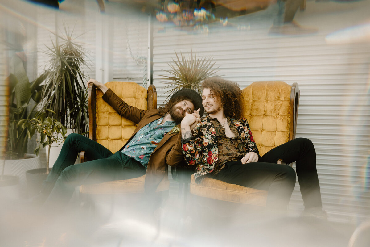 couple laying on yellow funky couch
