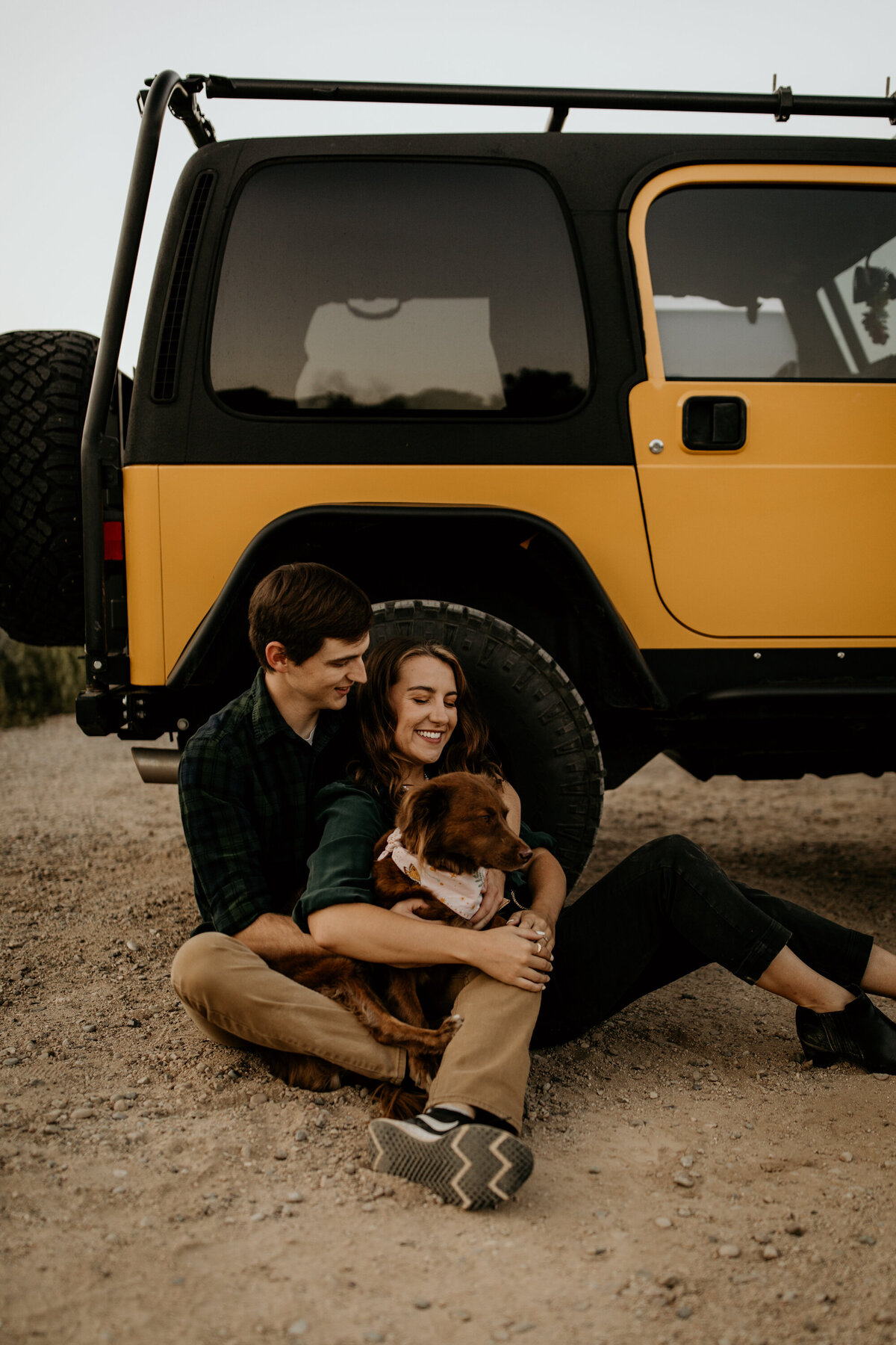 engaged couple sitting with their jeep at dog in Albuquerque New Mexico