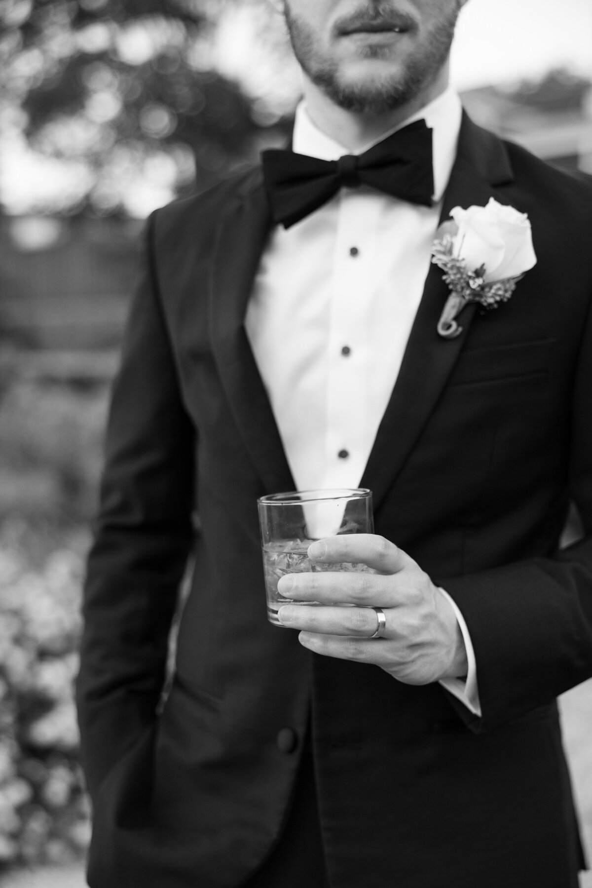 A close up of someone in a suite holding a drink glass