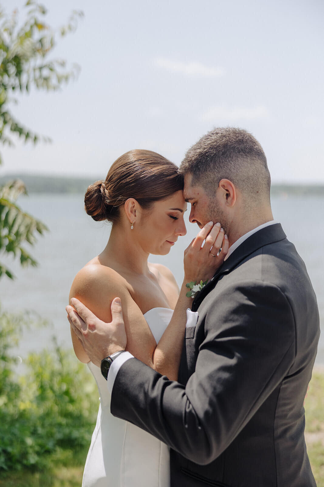 Bride and groom with heads together in tender embrace at Canandaigua Country Club, NY