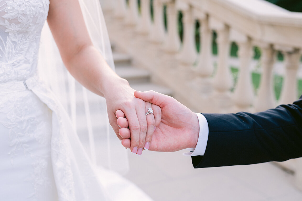 close up of bride and groom  holding hands