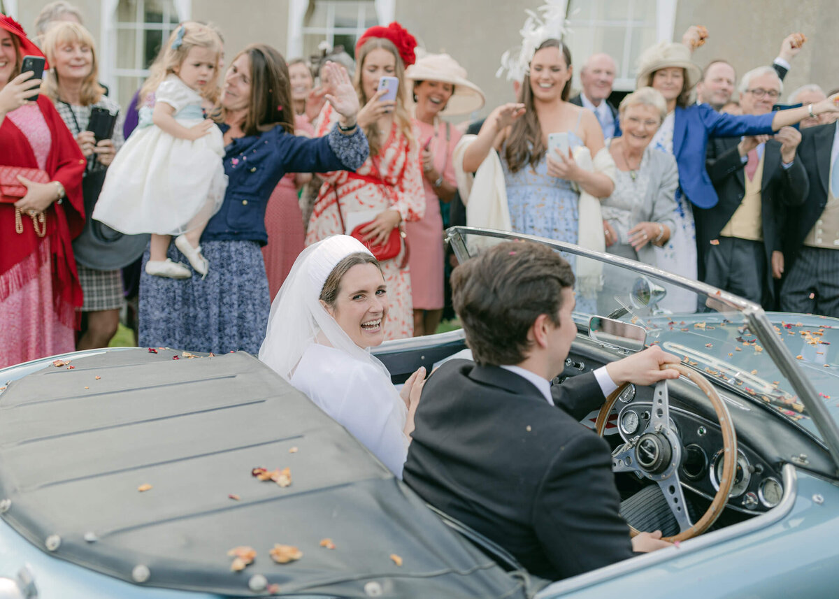 chloe-winstanley-weddings-confetti-exit-blue-austin-healey-car