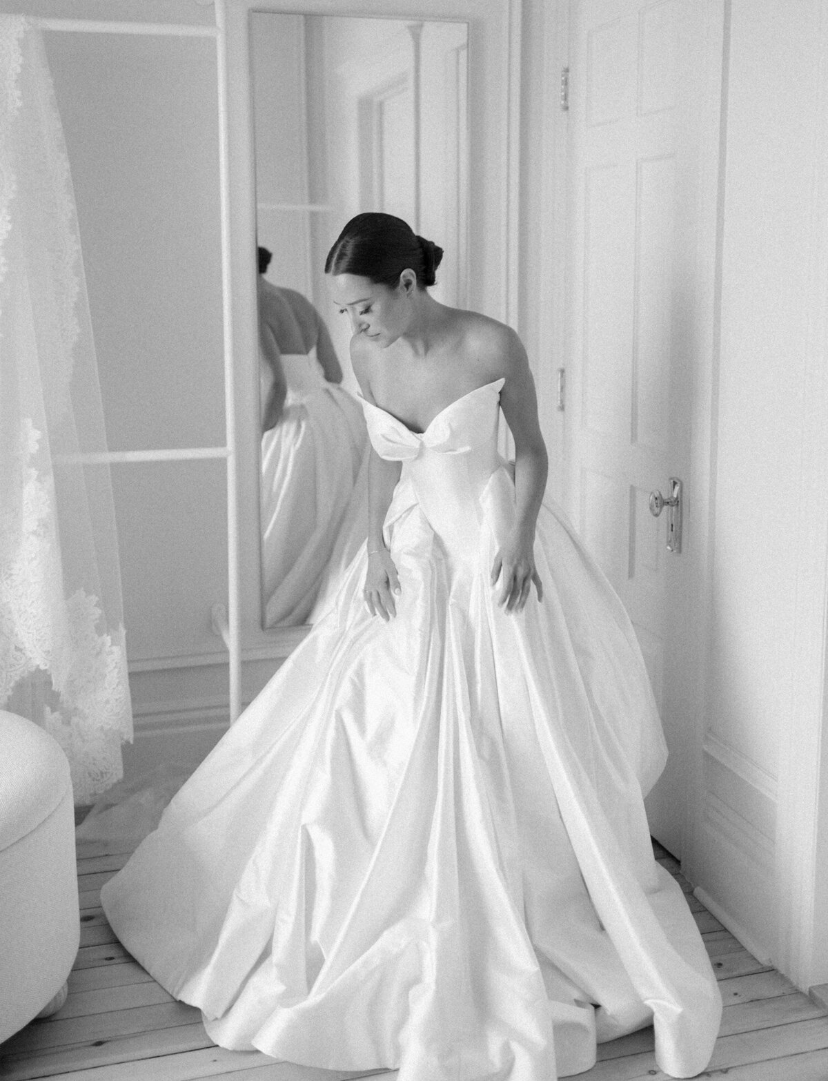 A bride slips into her raw silk Leah Dagloria wedding dress at 1 Room Hotel in Detroit, Michigan