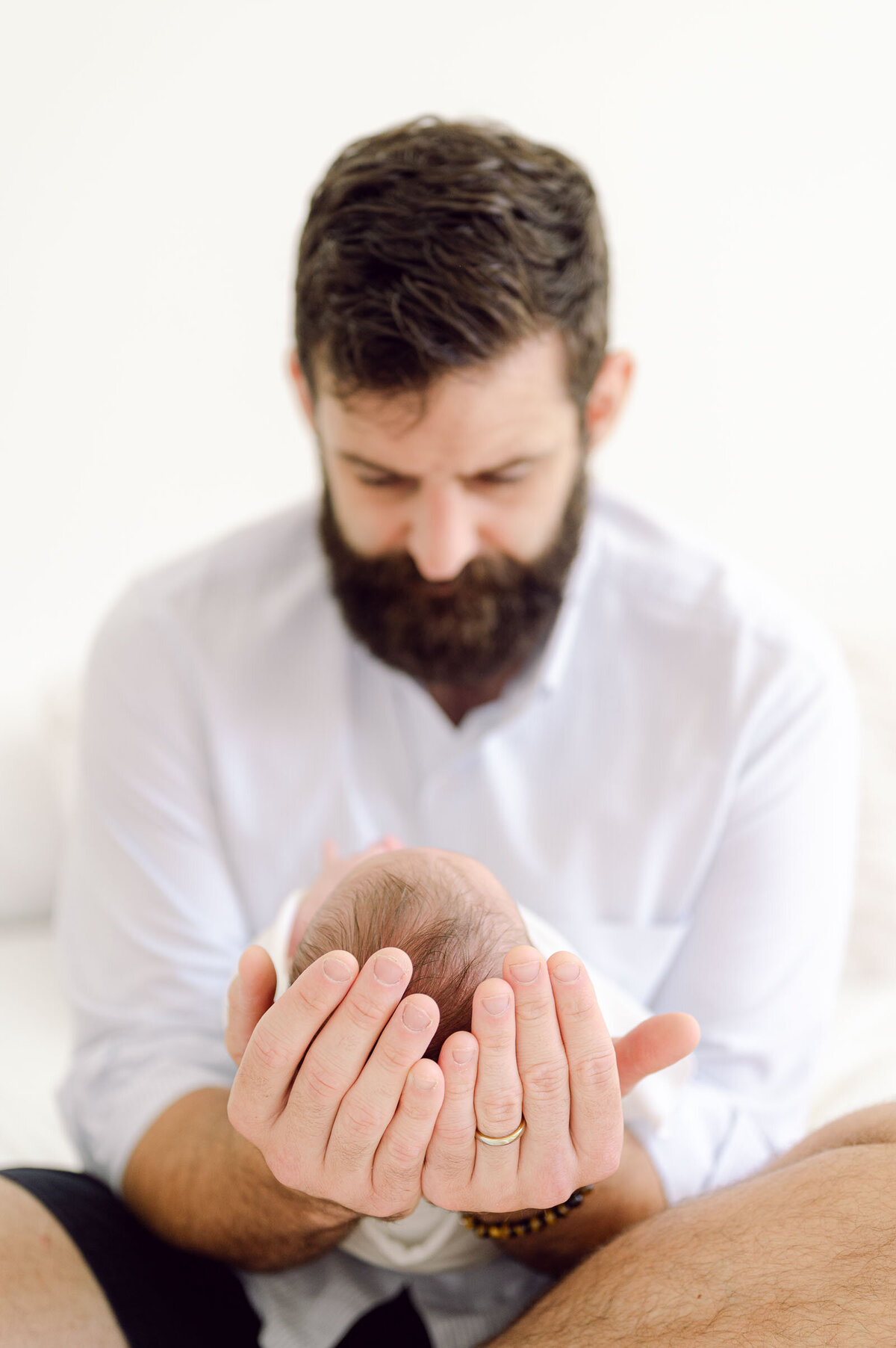 2023-newborn-dad-baby-head-in-hands