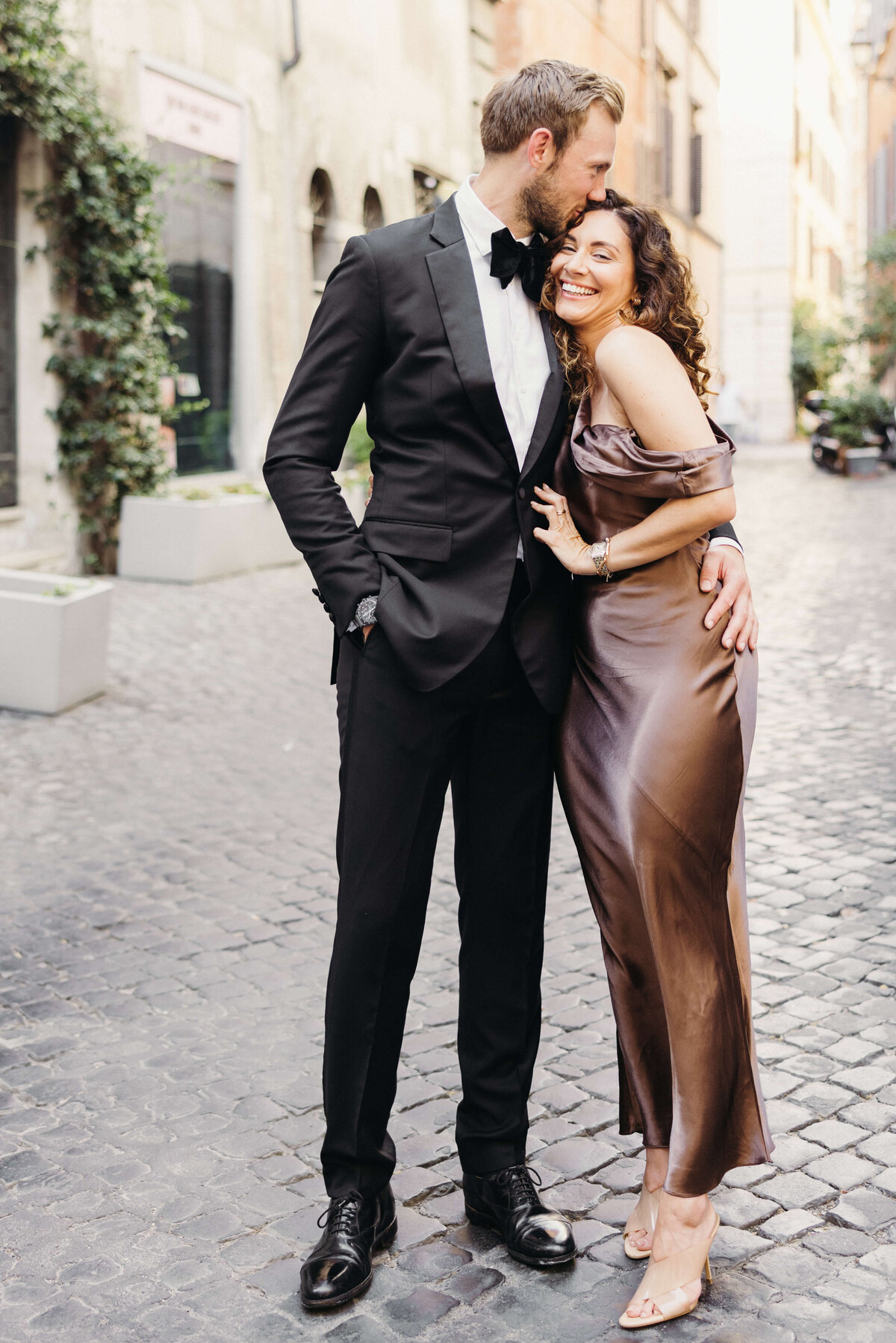Wedding guests laughing and embracing during Rome street celebration

