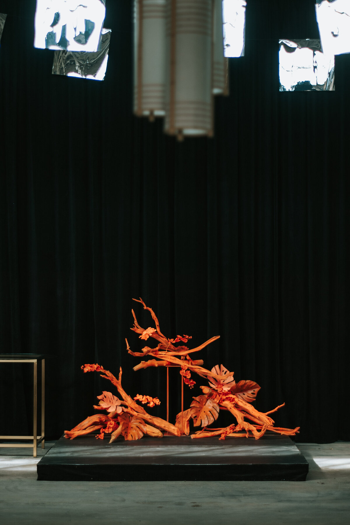 An installation of orange branches, leaves, and flowers decorate a Montreal wedding ceremony.