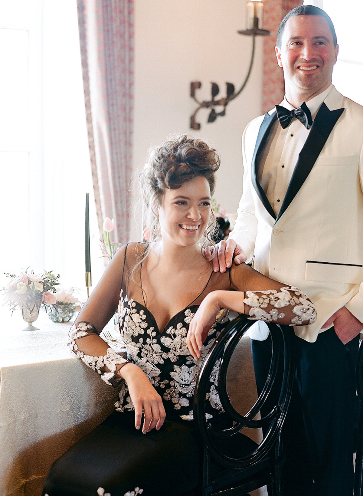 Bride and groom smiling while sitting at destination wedding reception