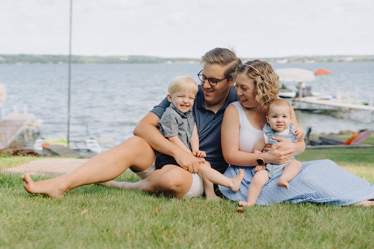 Family sitting on grass with kids at generational photoshoot in Finger Lakes, NY
