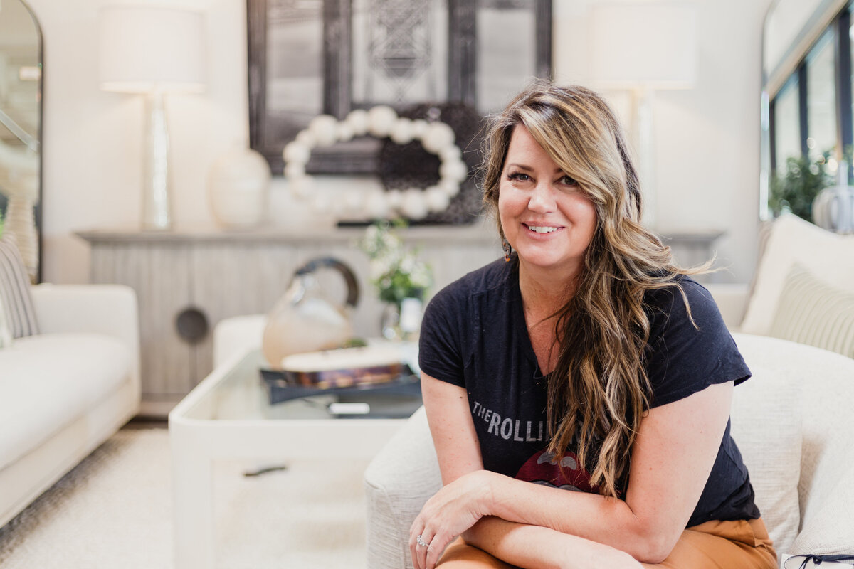 Interior Designer sitting in a staged room smiling at camera