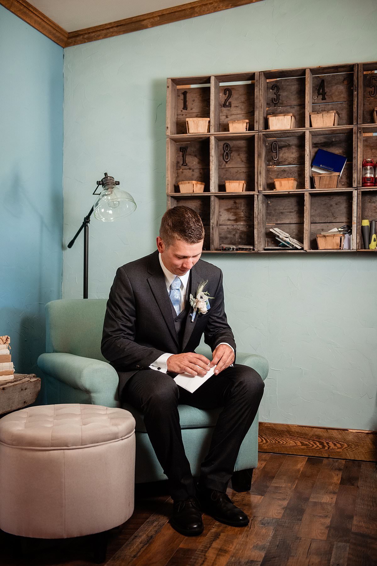 Groom sitting in cabin getting ready to read a letter from his fiance