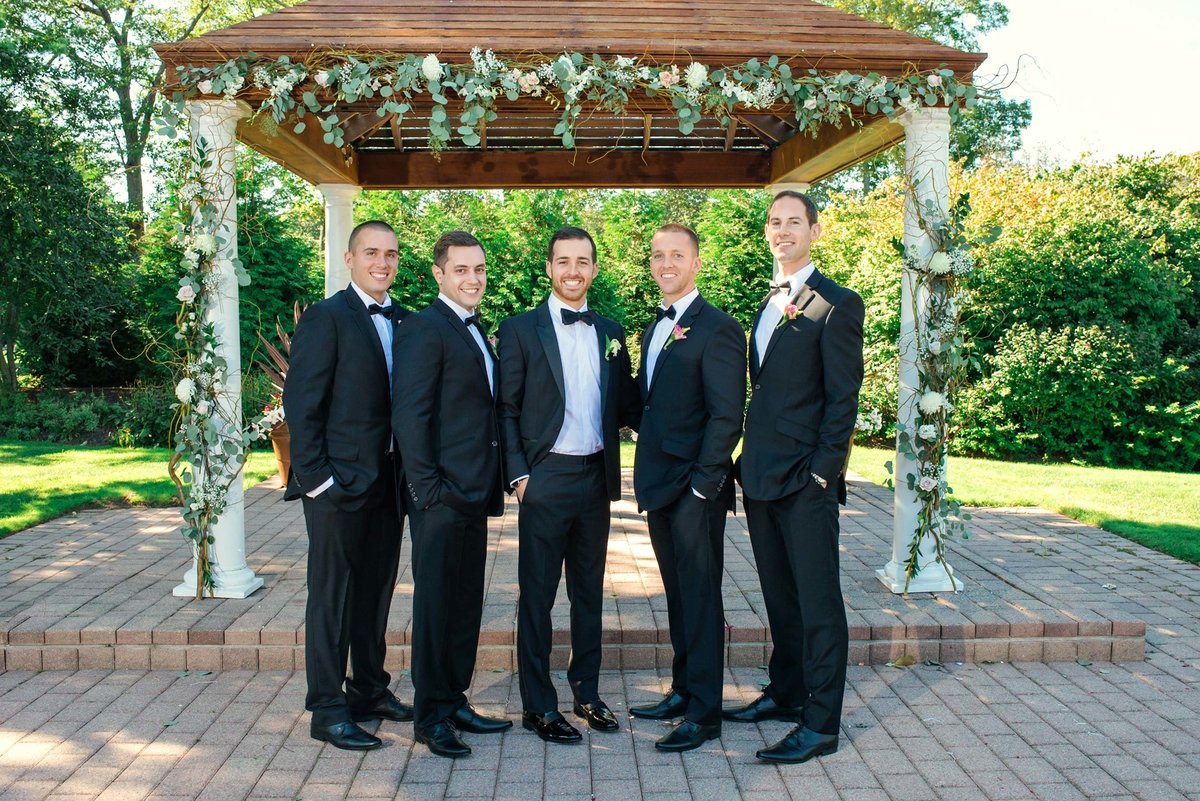 Groom and groomsmen posing by the altar at Stonebridge Country Club