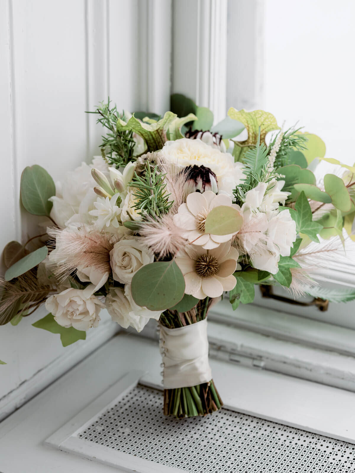 A bouquet of light pink flowers and green leaves