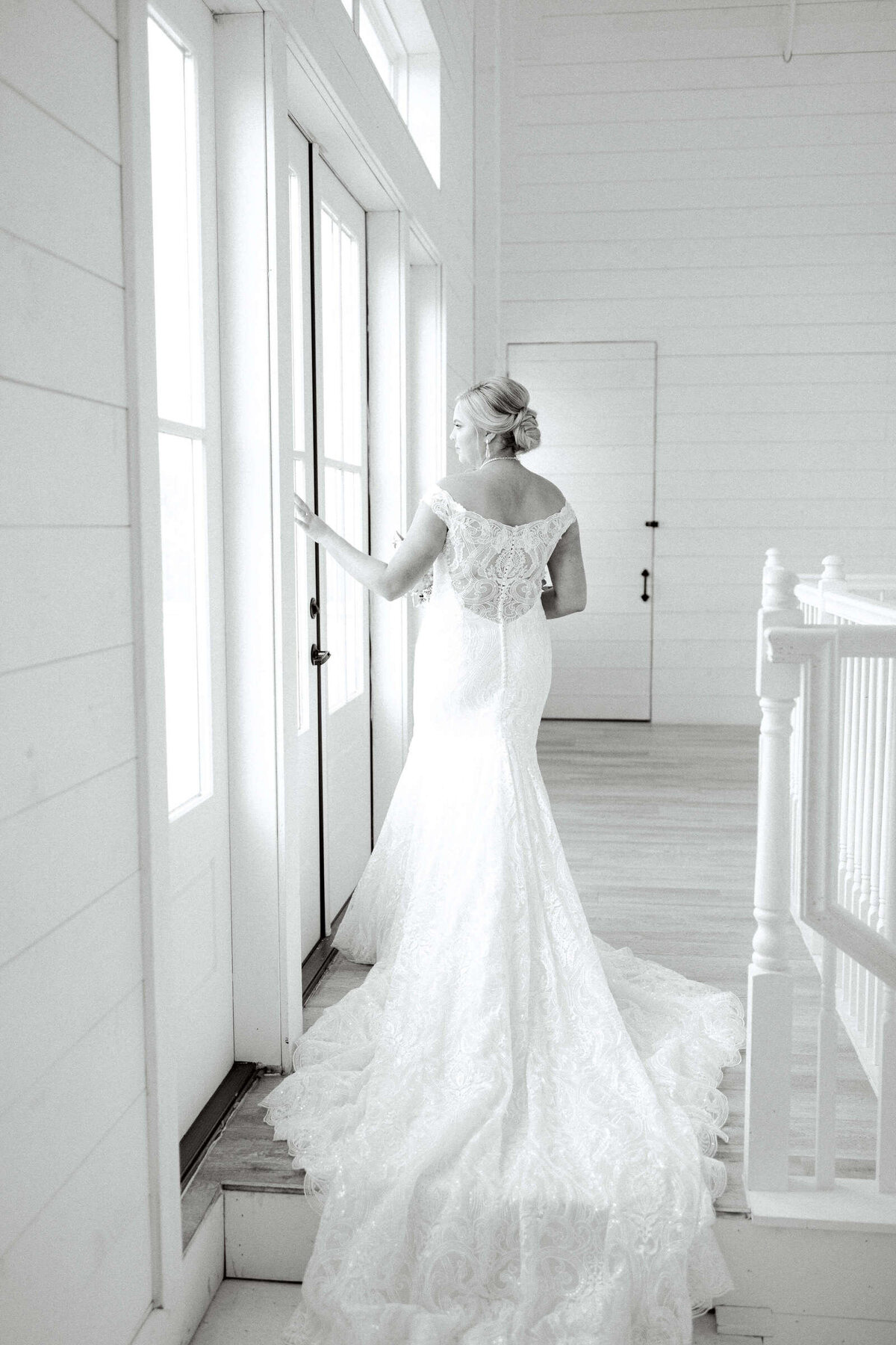 Elegant Texas bride looks out window in bridal suite
