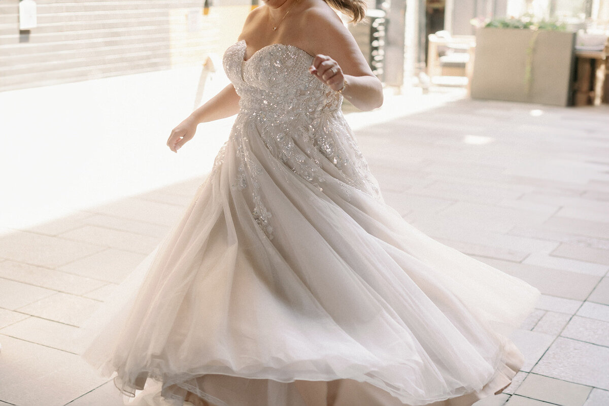 Bride spins in her lacey and sparkly  wedding dress.