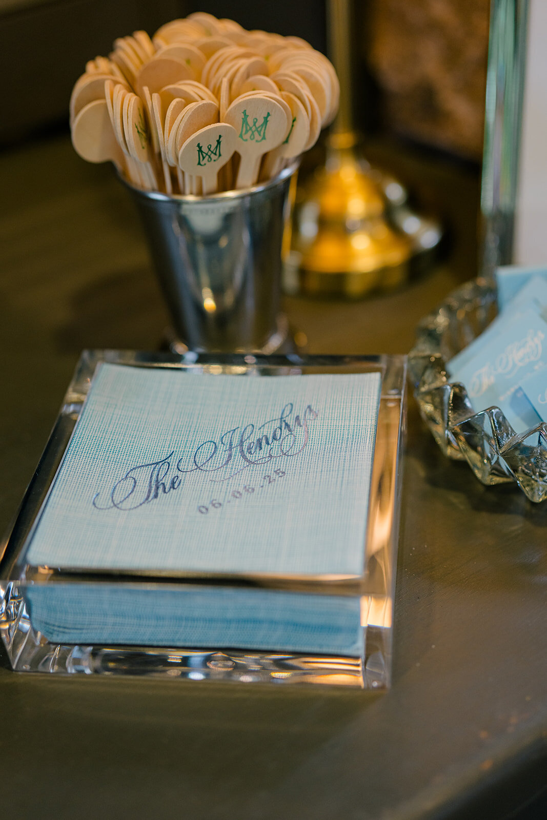 Custom wedding napkin with elegant blue calligraphy styled alongside delicate flowers and a small ceramic swan at Old Edwards Inn in Highlands, NC.
