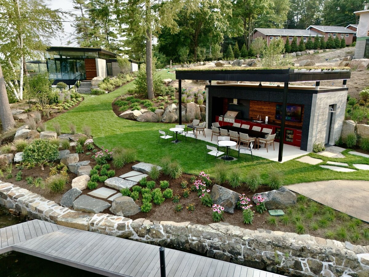View of outside cooking area with grass and lots of chairs and open space