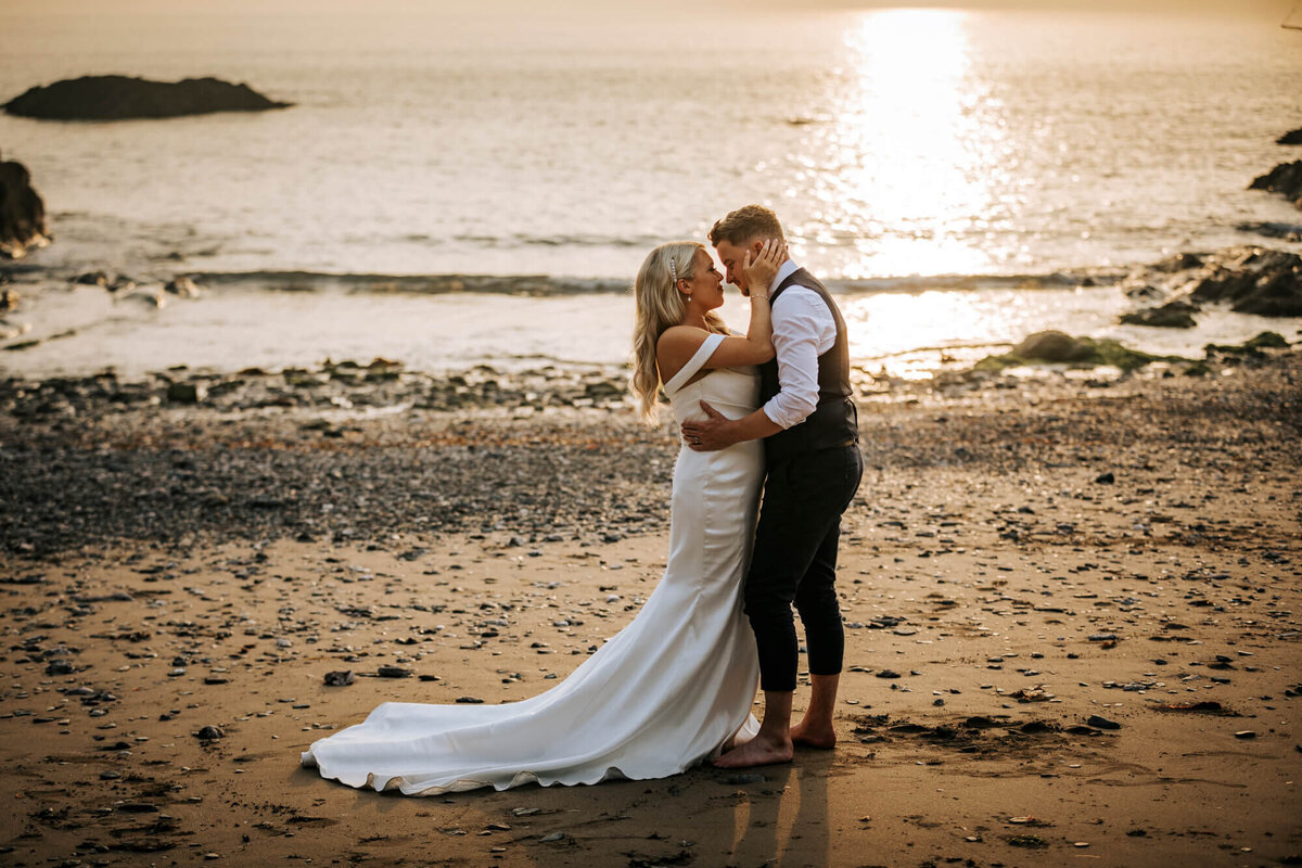 A bride and groom kissing on the beach