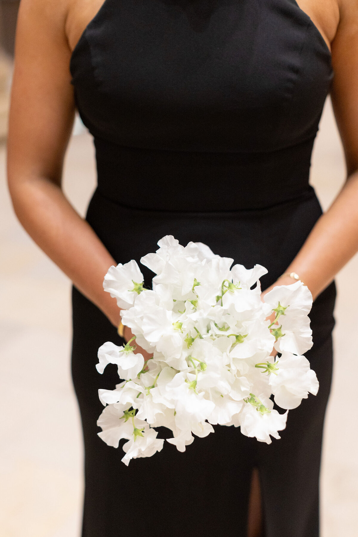 A close up of a woman holding a bouquet of white flowers. 