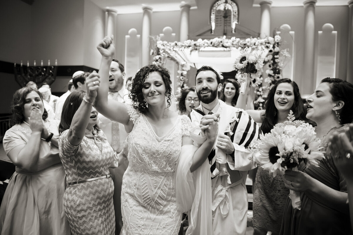 a bride and groom process down the aisle after the conclusion of their jewish wedding ceremony at Temple Emanu-El Closter. 