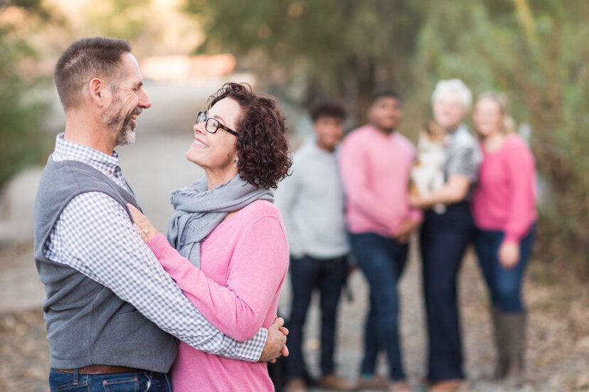 parents-hugging-kids-in-background