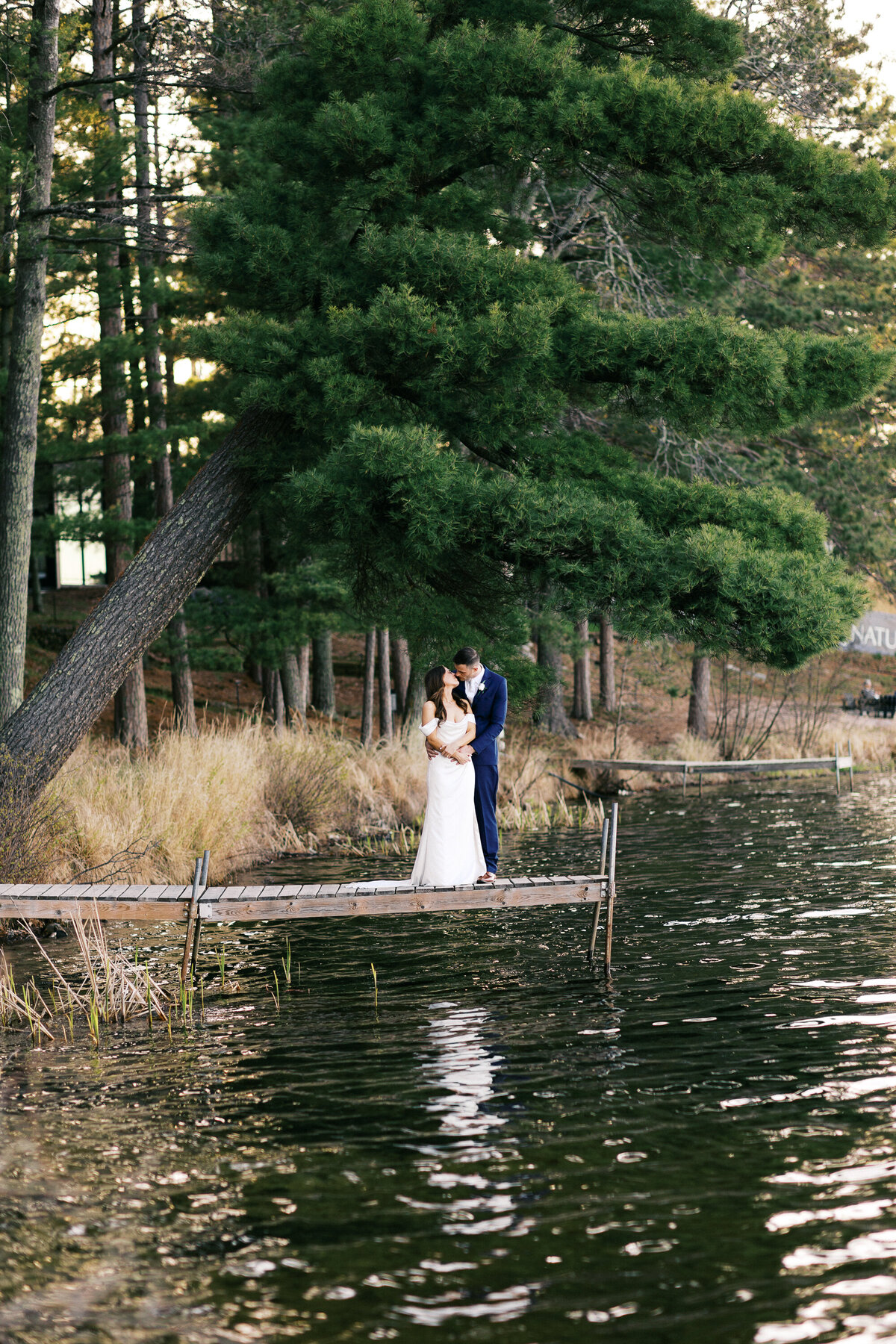 Bride and groom standing on the dock and kissing, at Catalyst by Nature Link wedding.