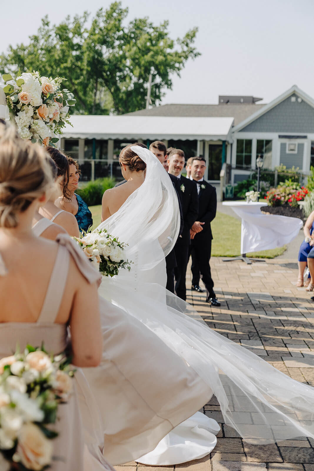 Bride with dress flowing , side shot of wedding ceremony at Canandaigua Country Club, NY