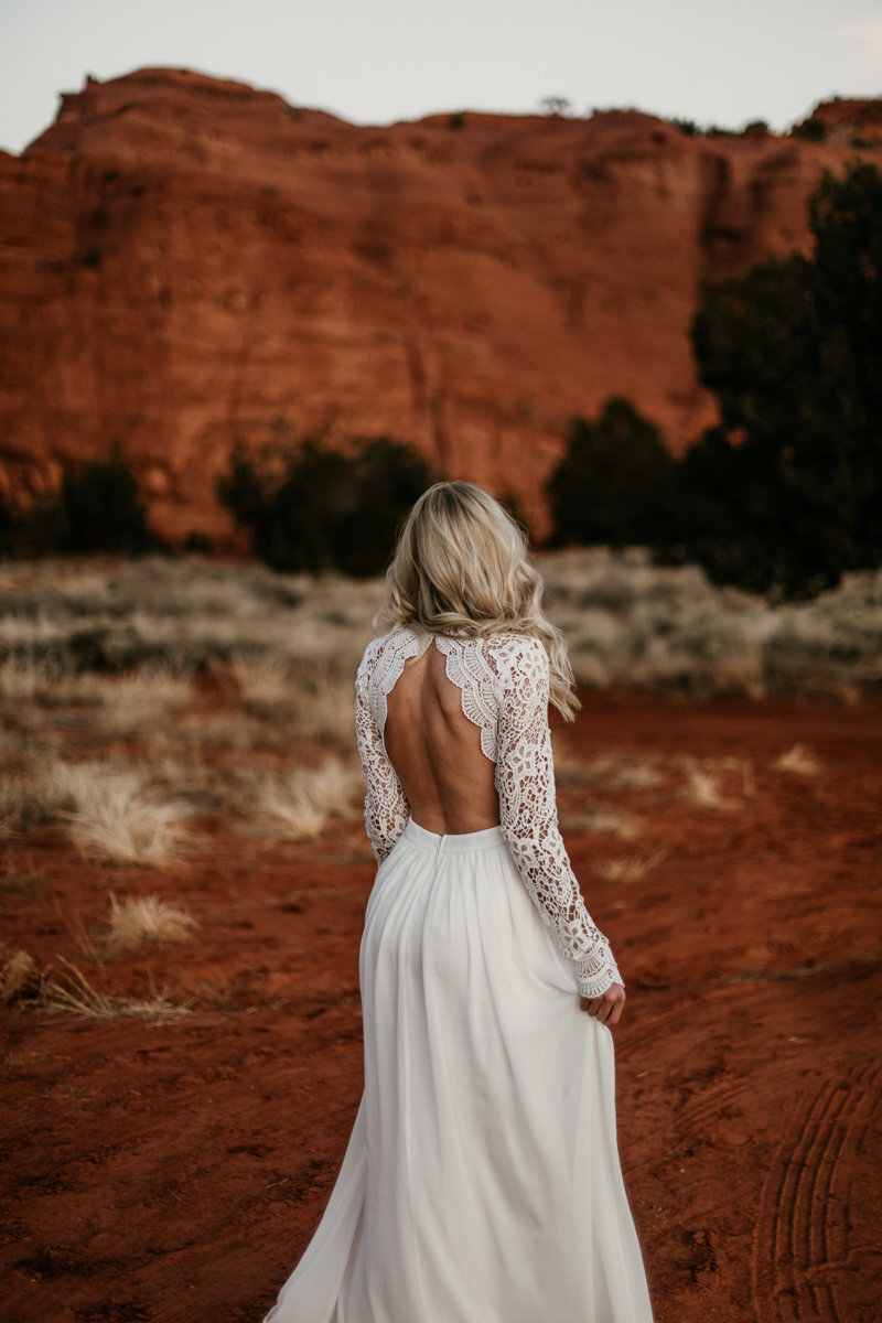 bride spinning in dress in front of red rocks