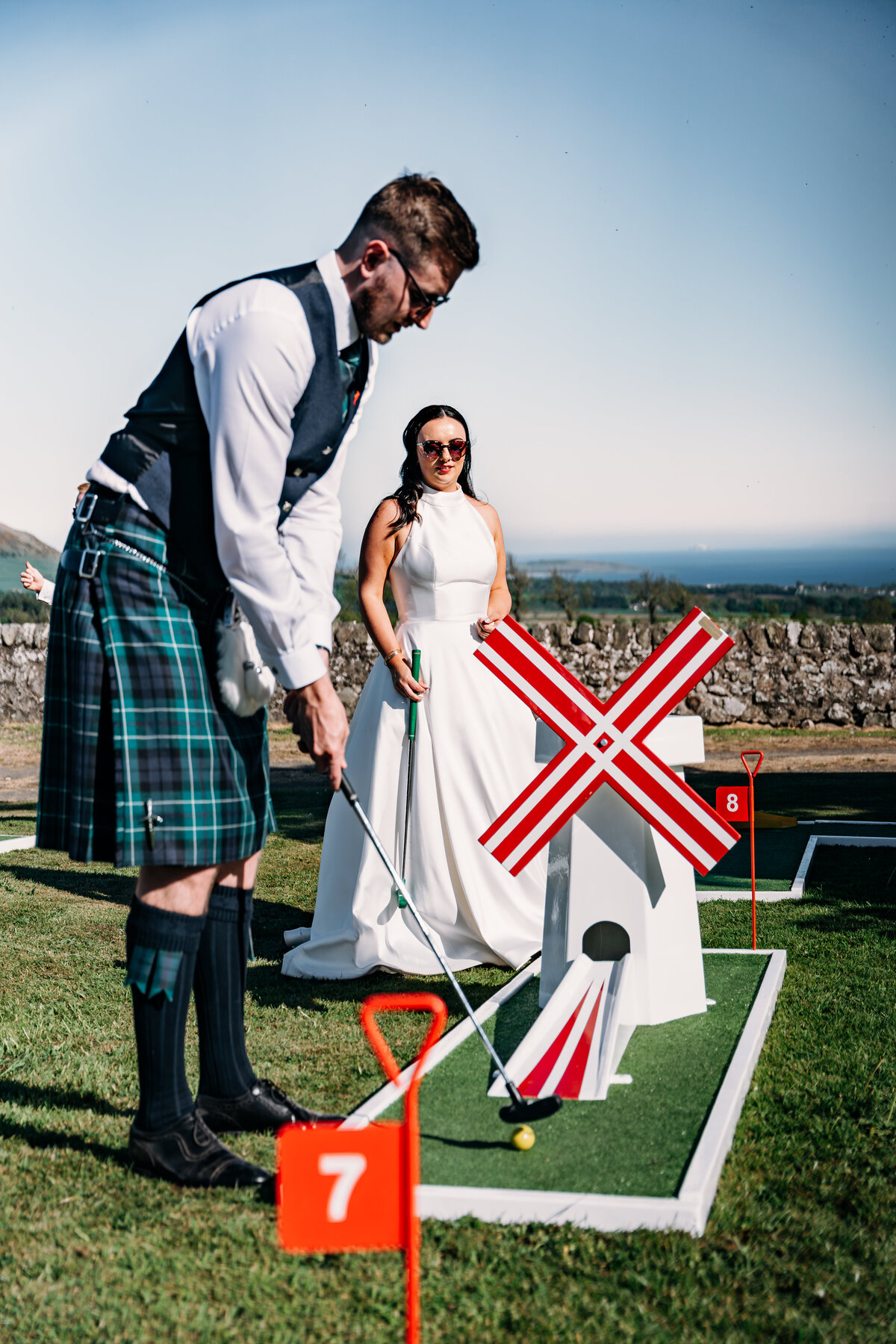bride and groom golfing on their wedding day at pratis barns