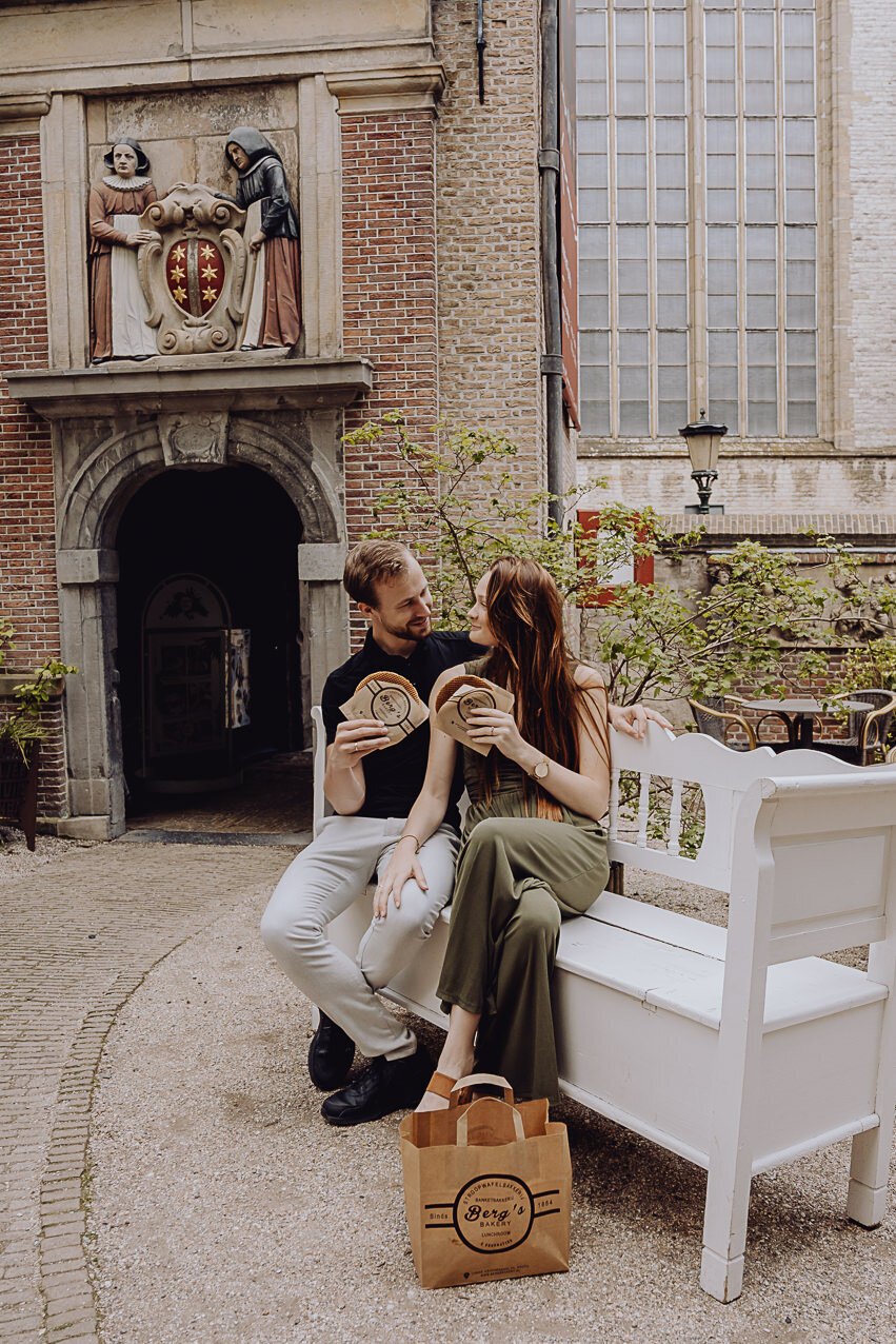 Stel op bankje met siroopwafel van Van Vliet bij het Museumcafe