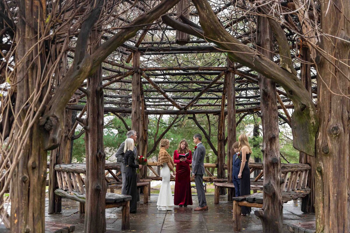 A small elopement ceremony in a wooden gazebo.