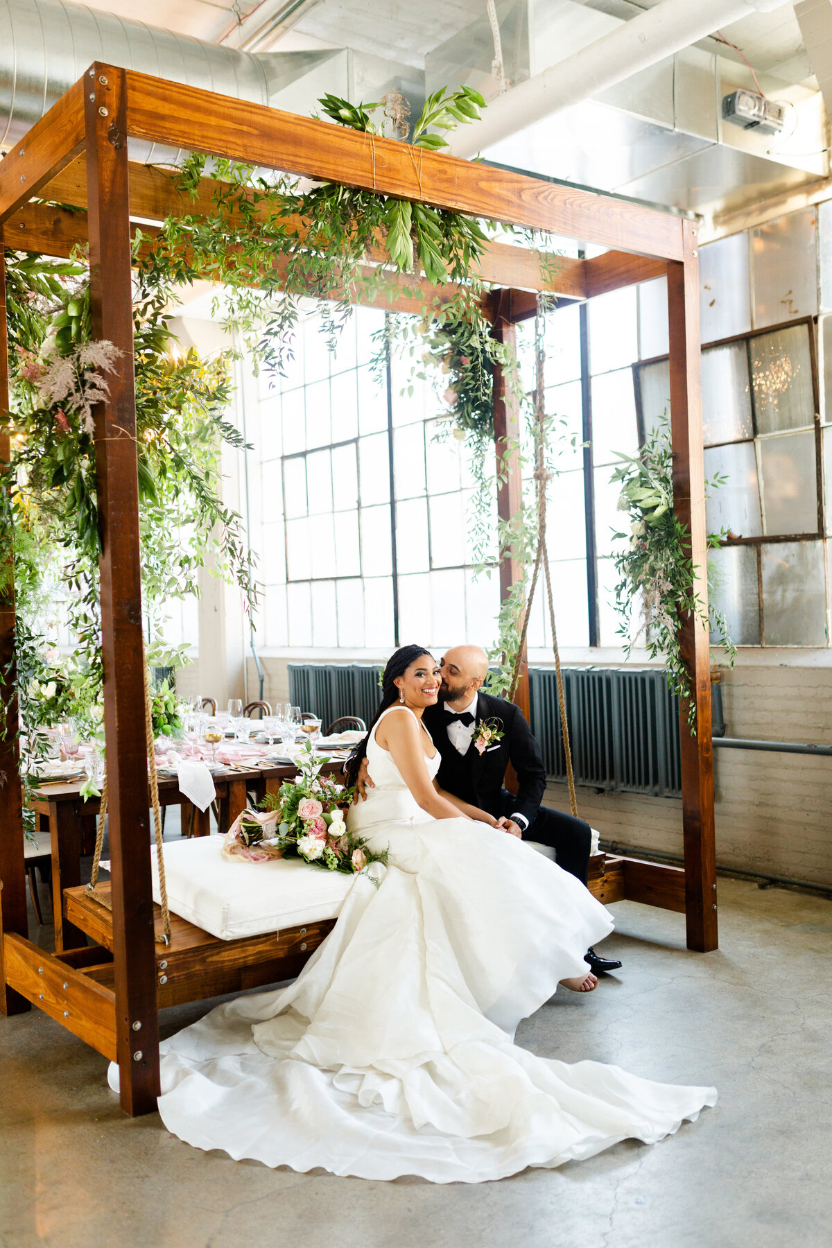 bride and groom sitting on swing from borrow rentals in Cleveland