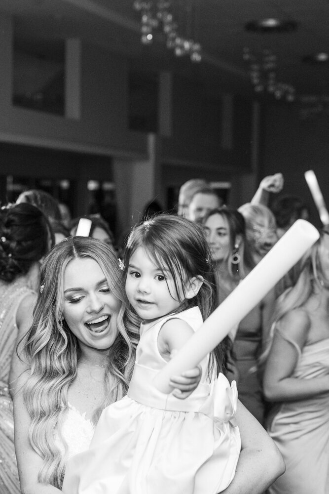 bride holding a little girl at wedding reception