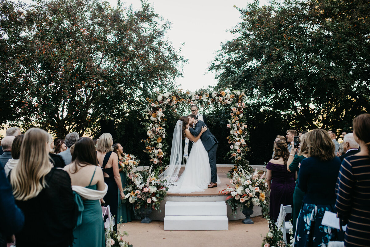 outdoor wedding ceremony with floral arbor