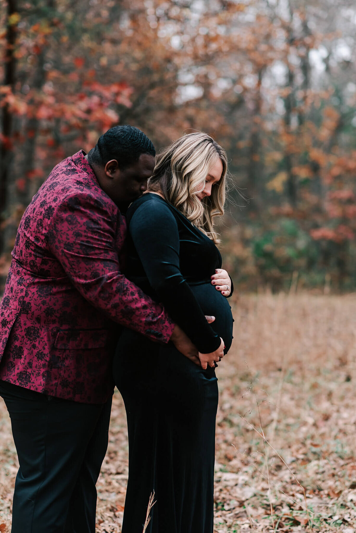 A father kissing his wife's shoulder during their maternity session in Northern Virginia