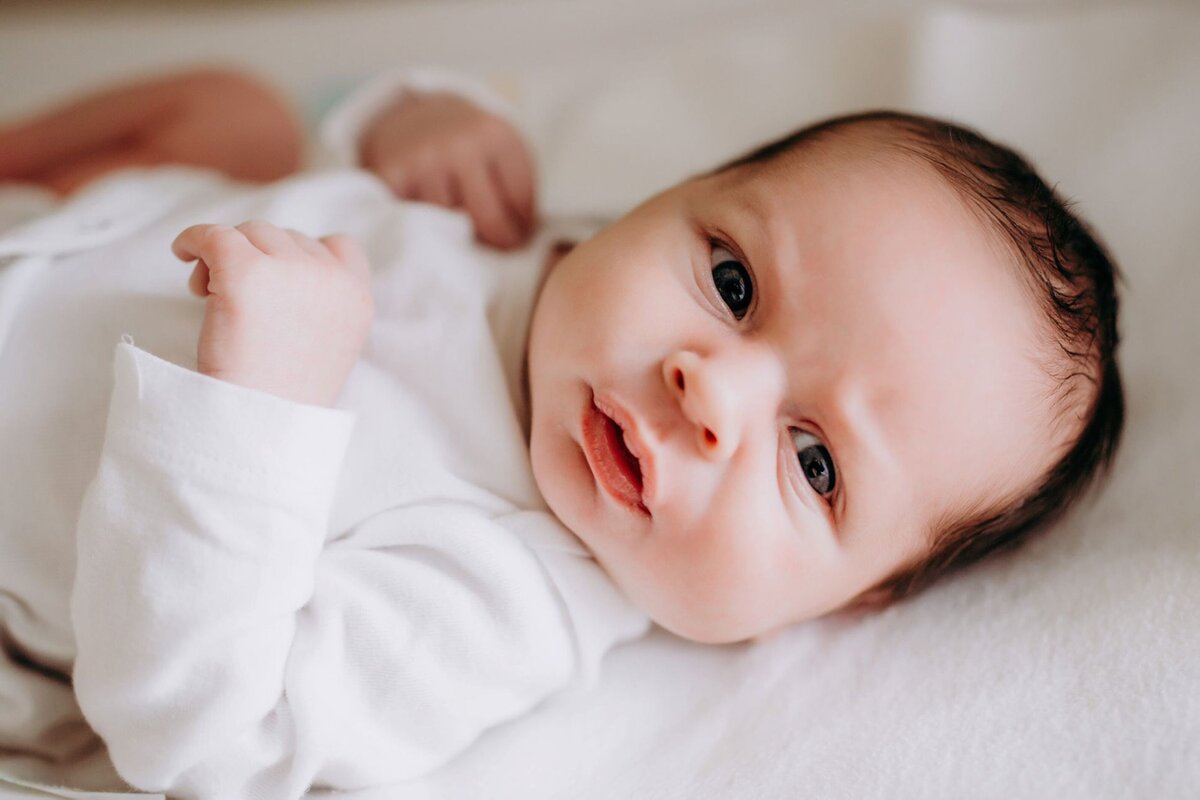 lifestyle portrait of newborn baby boy in white nursery by Francesca Marchese Photography