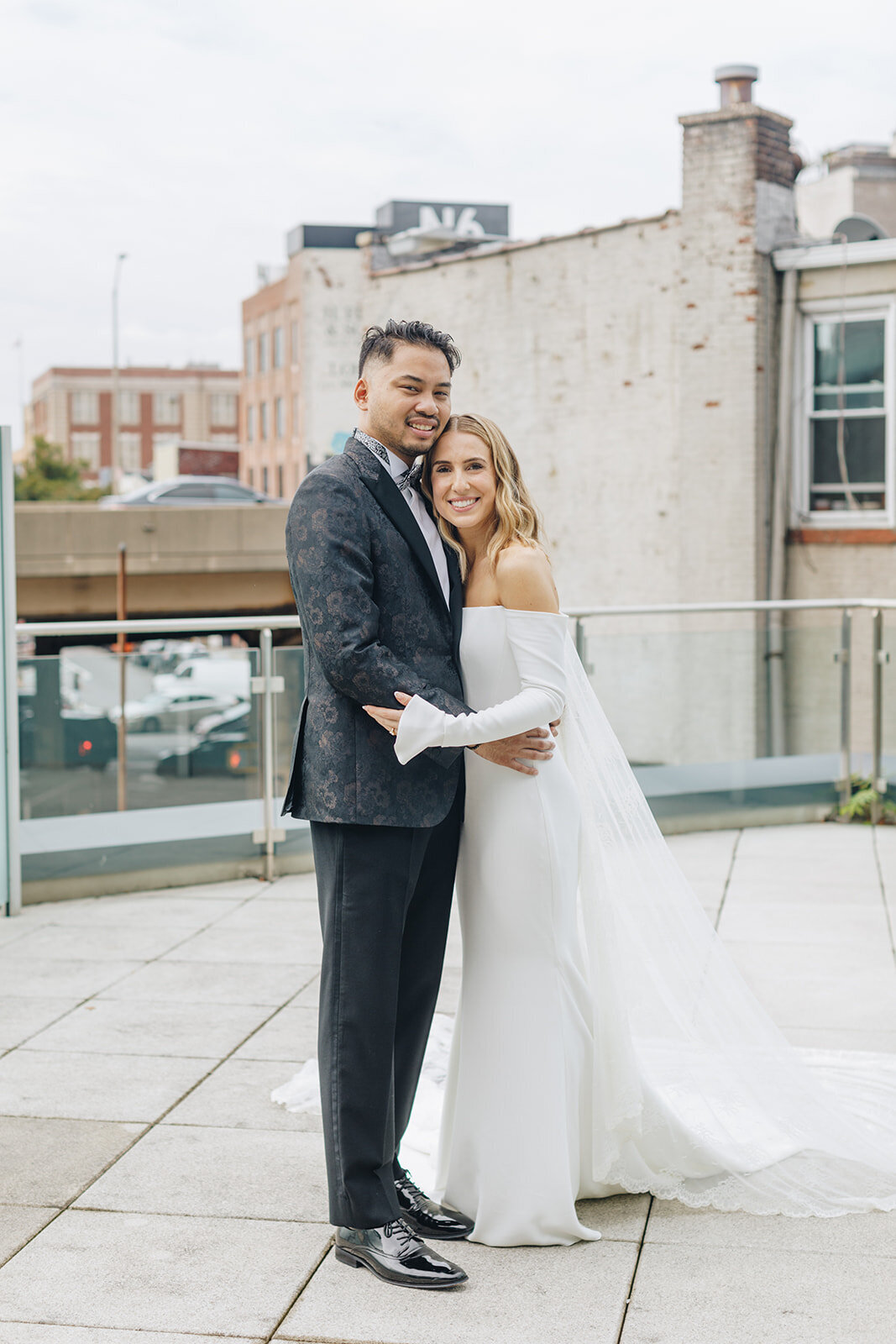 bride and groom embracing on a rooftop overlooking NYC