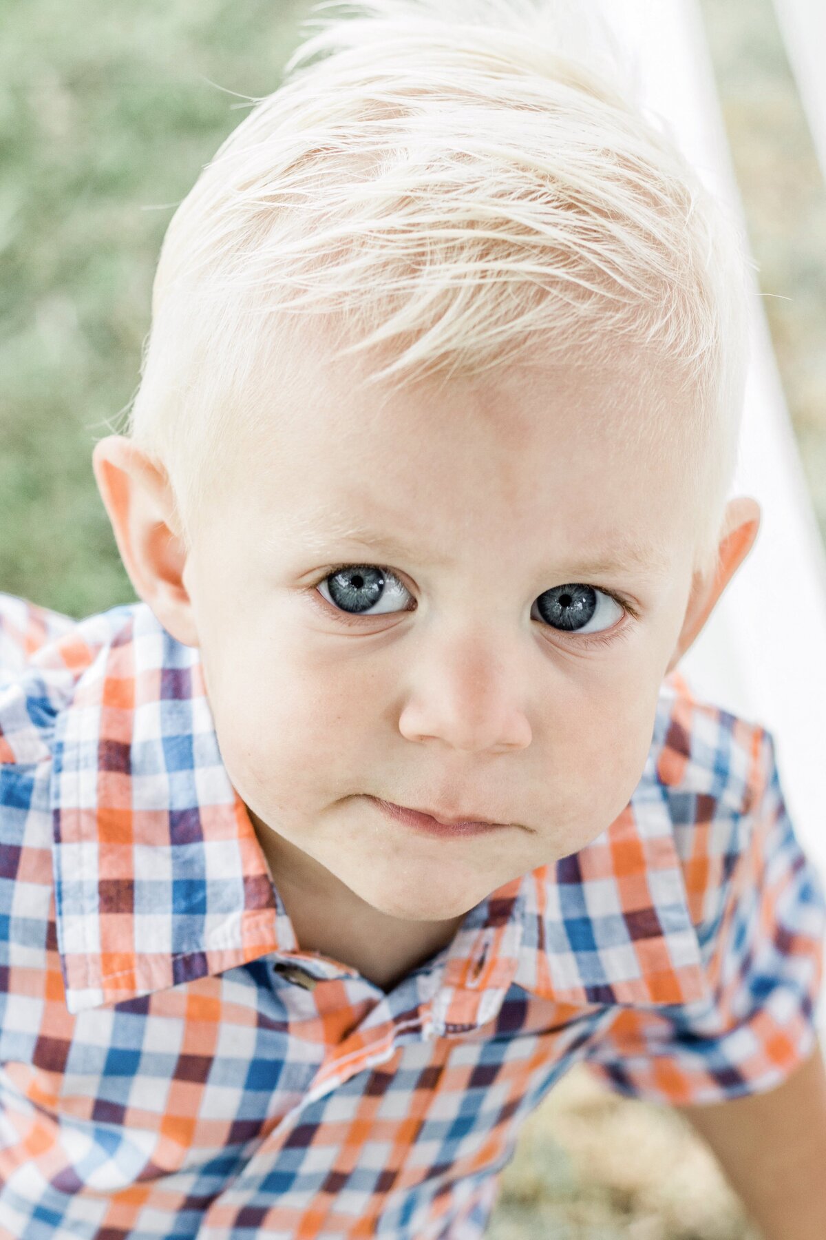 little boy with blue eyes looking up at the camera