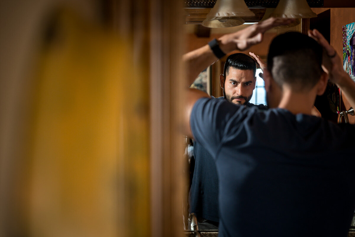 A candid moment of the groom getting ready in the villa at Airola Road Vineyard in Murphys, CA, as he prepares for his wedding day in the elegant and rustic setting.