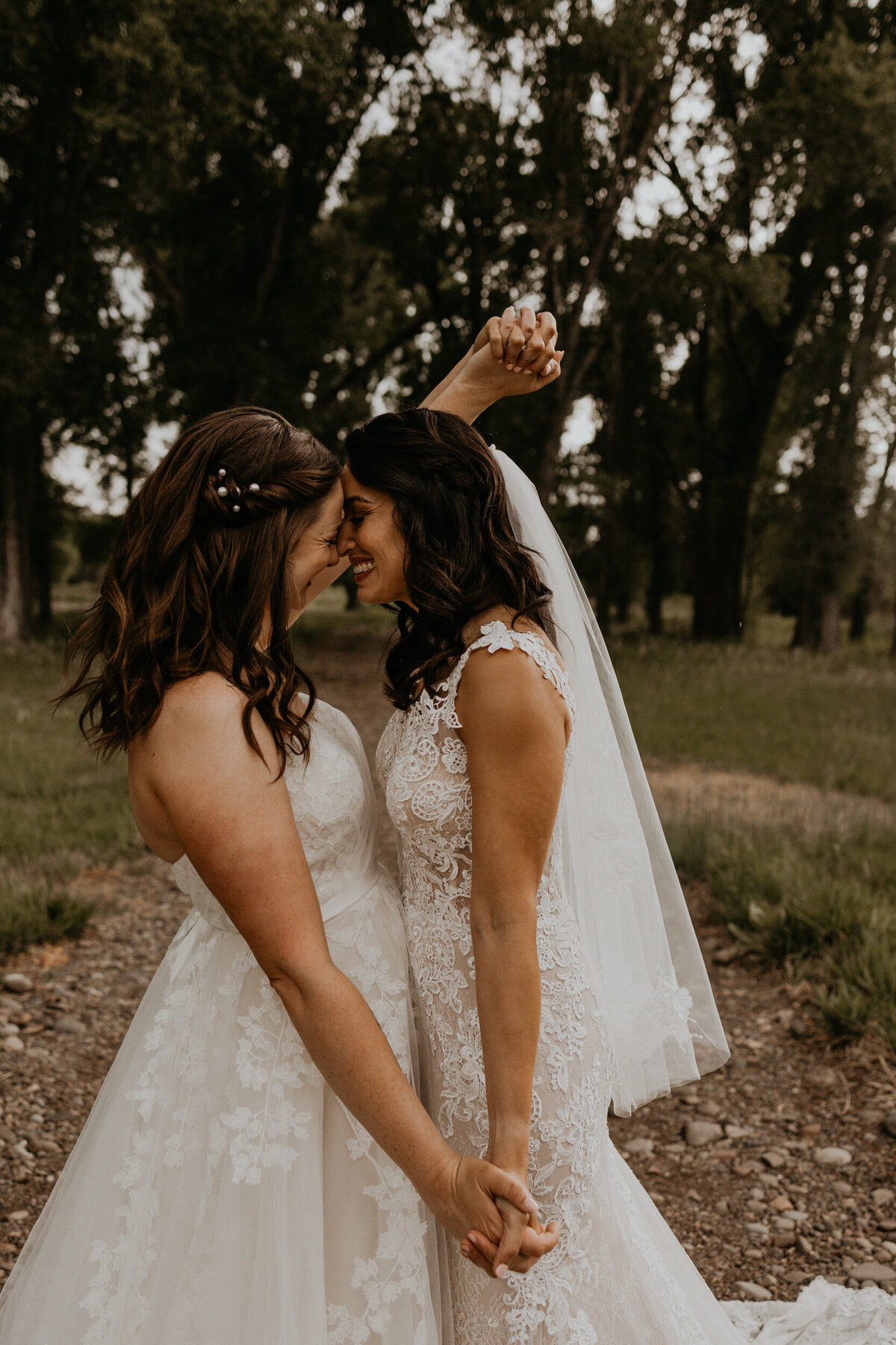 two brides holding hands and laughing