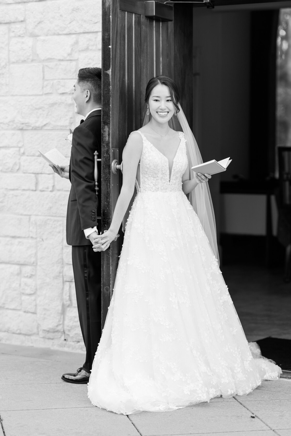 Sonny-and-kevin-sharing-a-first-touch-around-the-chapel-door-while-reading-their-vows-in-black-and-white