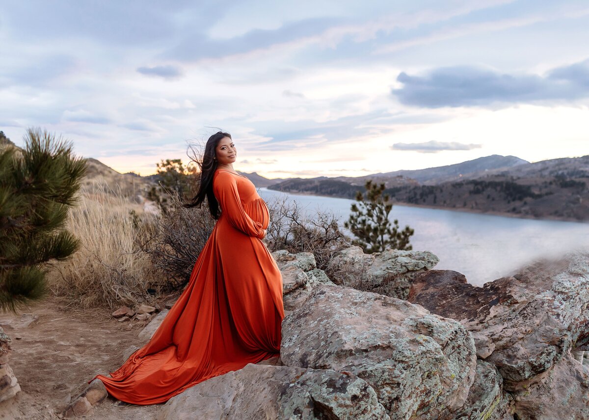 pregnant mama in rust gown at horsetooth at sunset