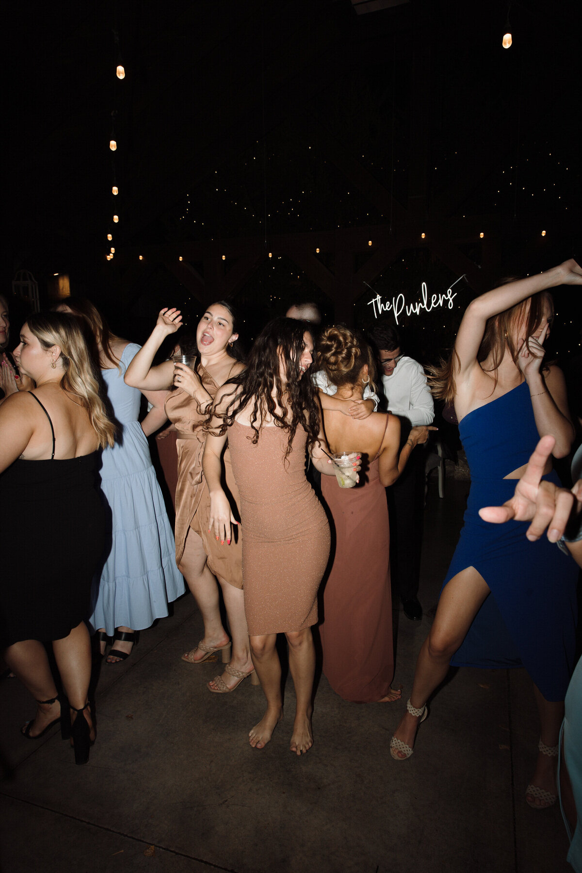 A flash photo of people dancing and having a good time. No faces are shown.