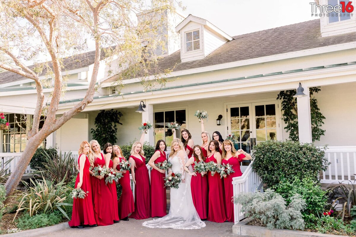 Bride poses with her Bridesmaids in front of the clubhouse