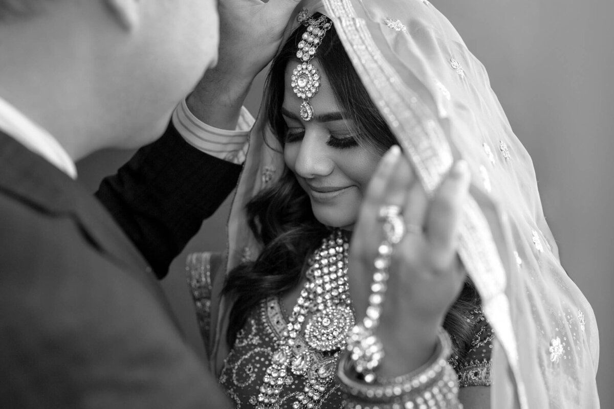 Bride with intricate jewelry and veil.