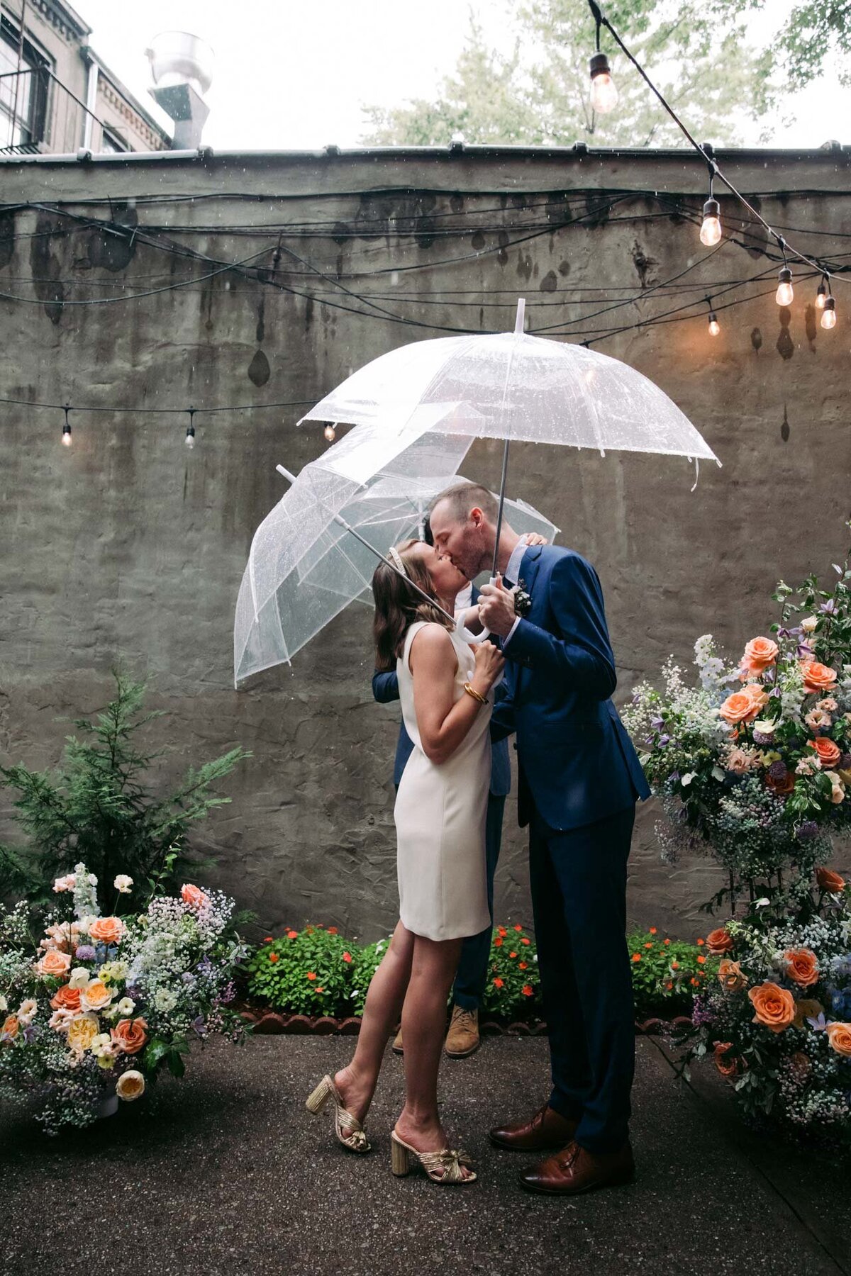 rainy brooklyn backyard microwedding with umbrellas and floral installation
