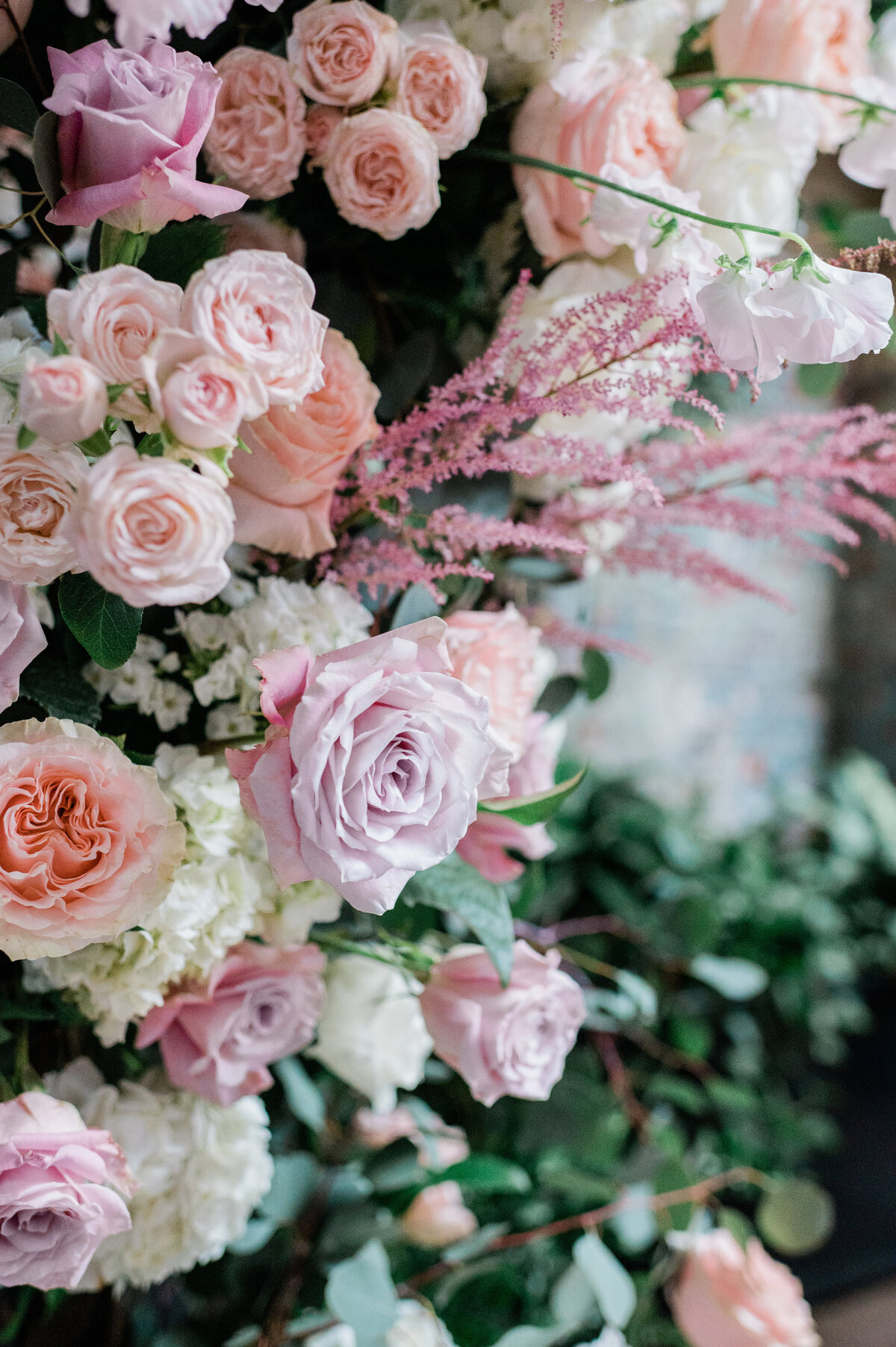 Pink and purple florals in a floral arch at the altar 