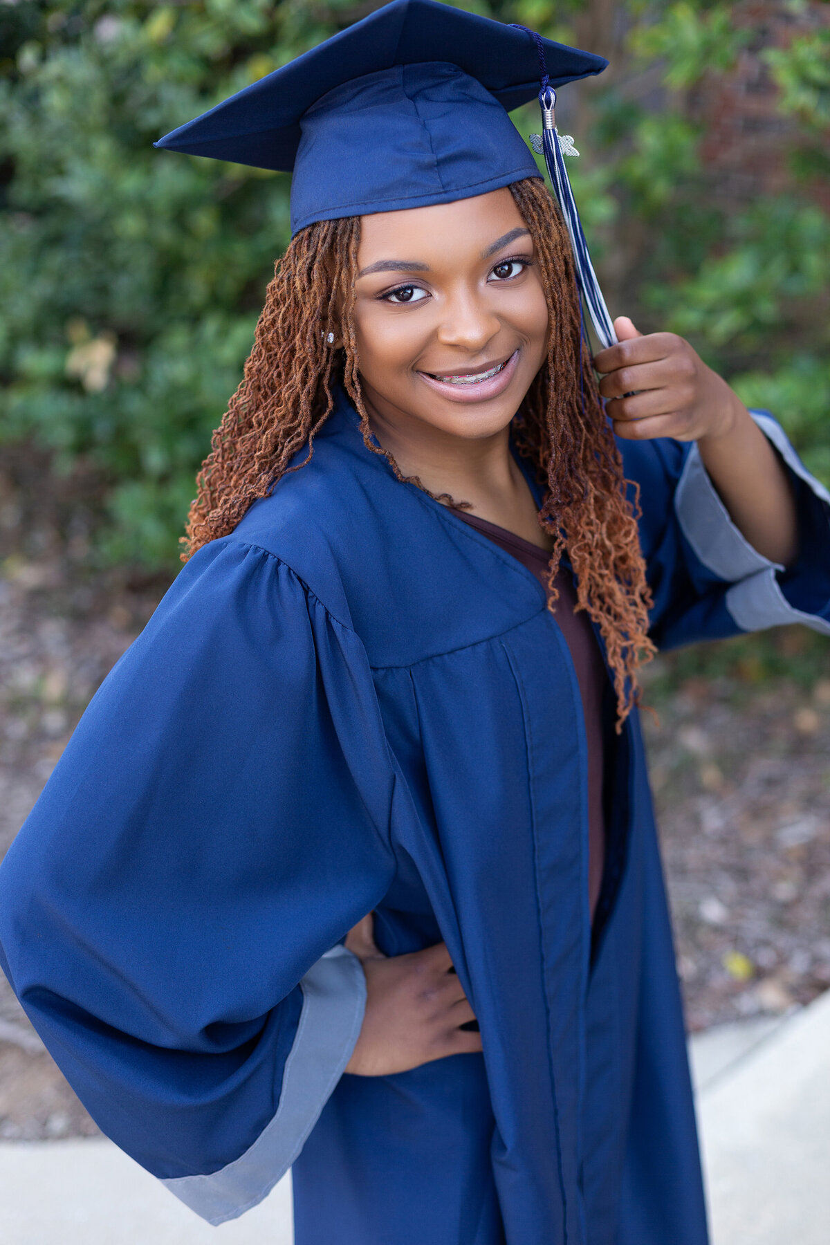 Clay Chalkville senior casually poses in her cap and gown in Birmingham, AL.